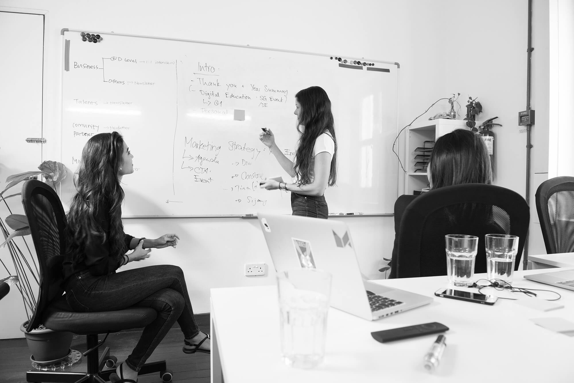 groupe de femmes en train de réfléchir devant un tableau