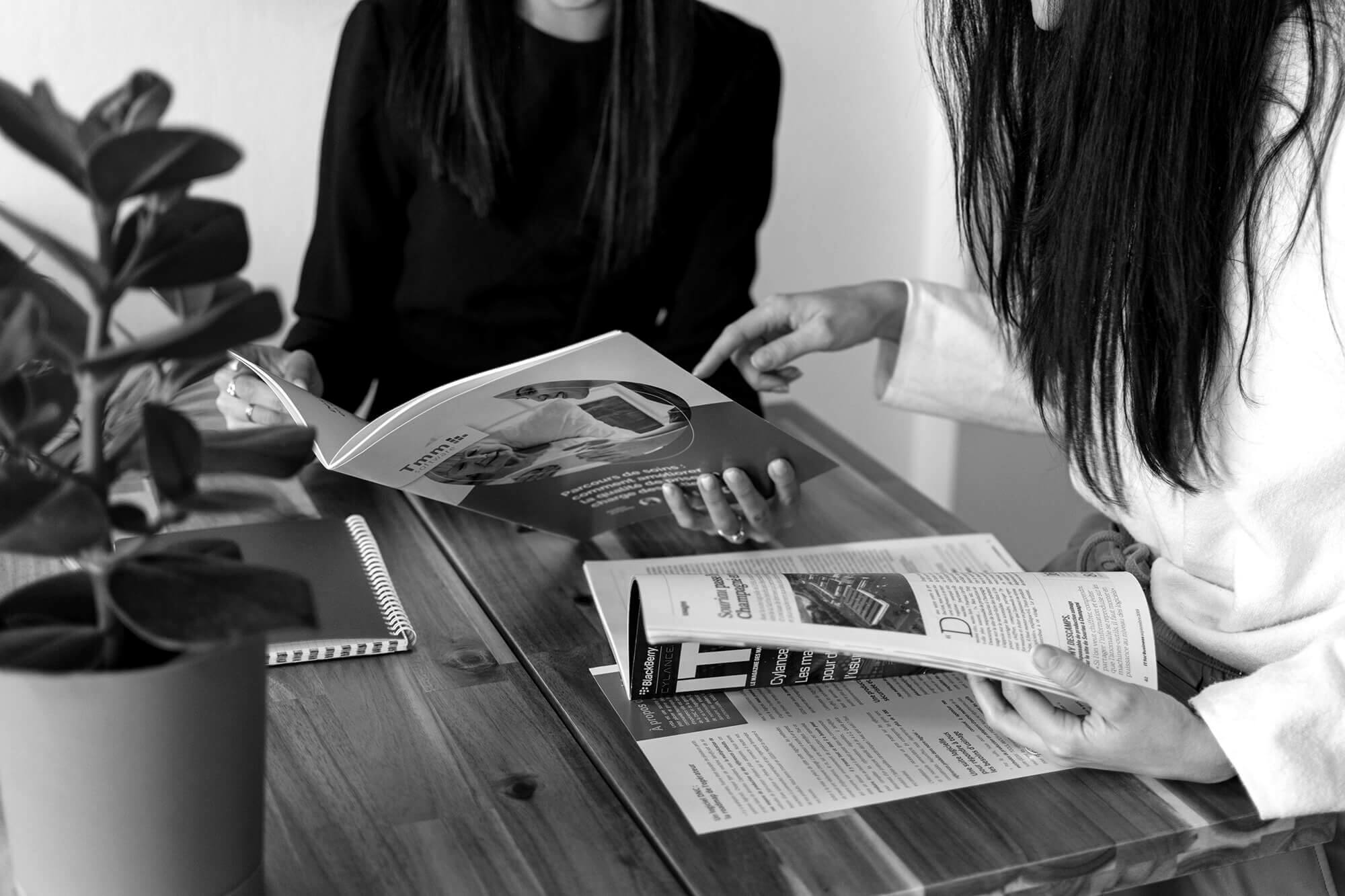 Deux personnes discutant de retombées presse IT autour d'une table