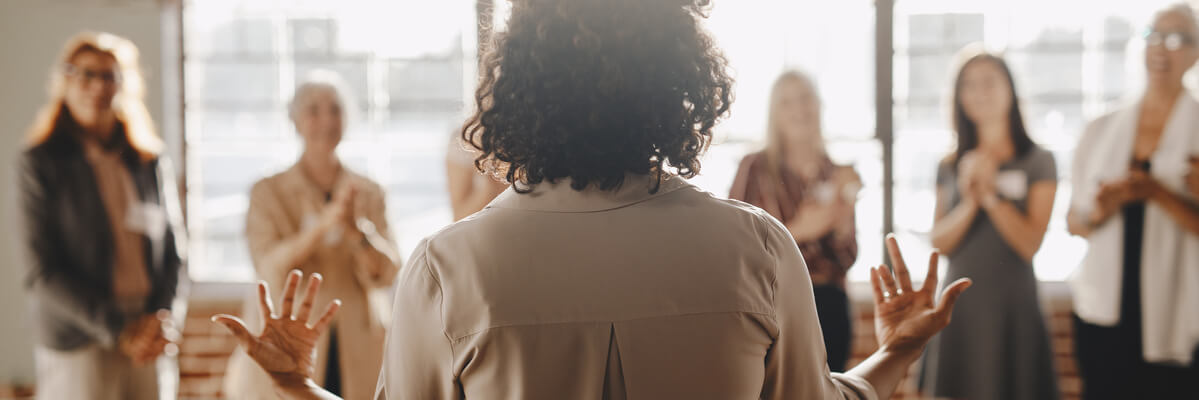 Femme parlant à un groupe de personne debout